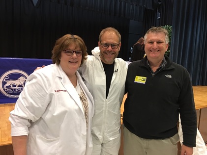 Dr. Drizzle poses for a photo with Alton Brown and husband Steve Jones